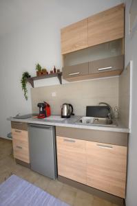 a small kitchen with wooden cabinets and a sink at Verano Apartments in Kalymnos