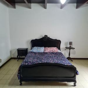 a bedroom with a bed with a black headboard at Casarão Hostel Peró in Cabo Frio