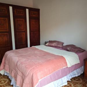 a bedroom with a bed with two pillows on it at Casarão Hostel Peró in Cabo Frio