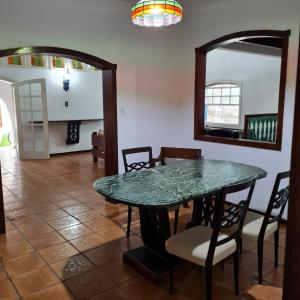 comedor con mesa, sillas y espejo en Casarão Hostel Peró, en Cabo Frío
