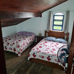 1 dormitorio con 2 camas y ventana en Casarão Hostel Peró, en Cabo Frío