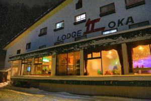 ein Geschäft vor einem Gebäude im Schnee in der Unterkunft Naeba Lodge Oka in Yuzawa