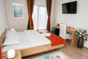a small bedroom with a bed and a desk at Stil Motel & Spa in Tăşnad +50 photos