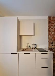 - une cuisine avec des placards blancs et un évier dans l'établissement Võru apartment 4, free parking, à Tartu