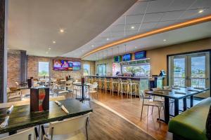un restaurante con mesas y sillas y un bar en Vibrant Home with Theater Room & Pool Table near Disney by Rentyl - 7713G, en Orlando