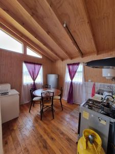 a kitchen and dining room with a table and a stove at Cabañas Isabella in Chonchi