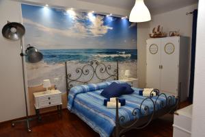 B&B LE DUE ISOLE في نوورو: غرفة نوم بسرير مع لوحة للمحيط