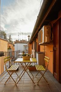 einen Tisch und zwei Stühle auf dem Balkon in der Unterkunft Italian design small attic in Bologna