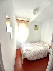 um pequeno quarto com uma cama e uma janela em El Mirador em Higuera de la Sierra