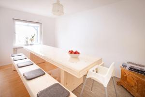 a kitchen with a table with a bowl of fruit on it at Gemütliches Haus mit Holzofen & Garten in Landshut