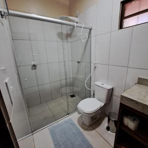 a white bathroom with a shower and a toilet at Casa Nirvana para Temporadas in Alto Paraíso de Goiás