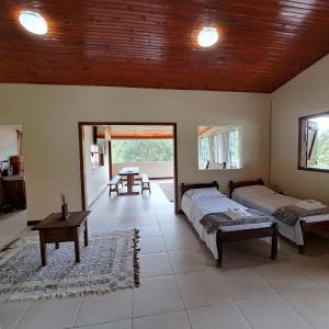 a bedroom with two beds and a table in it at Casa Nirvana para Temporadas in Alto Paraíso de Goiás