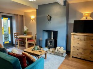 sala de estar con sofá y chimenea en Sun Street Cottage - with log burner, jet bath and Summerhouse en Haworth