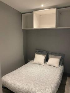 a bedroom with a bed with two white pillows at T3 indépendant avec jardin in Saint Malo