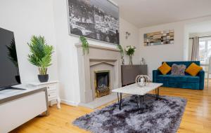 a living room with a fireplace and a blue couch at Saviour Manor in Kettering