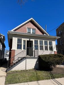 uma casa branca com um tijolo vermelho em Sunny 2 BR Apartment west of Chicago in quaint Forest Park center em Forest Park