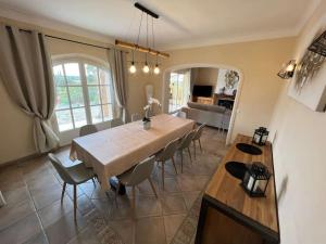jadalnia i salon ze stołem i krzesłami w obiekcie Grande villa avec piscine et vue panoramique w mieście Saumane-de-Vaucluse