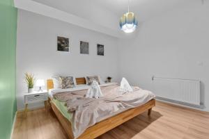 a white bedroom with a large bed in it at Asteri Garden & Terrace Apartment in Sinaia