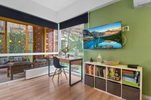 a living room with a table and a tv on a wall at Asteri Garden & Terrace Apartment in Sinaia