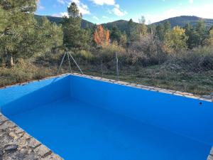 una piscina azul con una montaña en el fondo en Cotanda - Casa de Montaña aislada en el Macizo del Penyagolosa, en Puertomingalvo