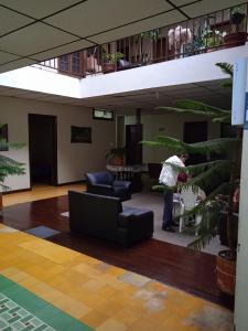 a man standing in a room with a plant at Residencias MARGARITA in Manizales