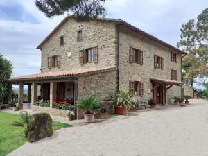 een oud stenen gebouw met planten ervoor bij Podere Belvedere Villa Classic Tuscan in Magliano in Toscana