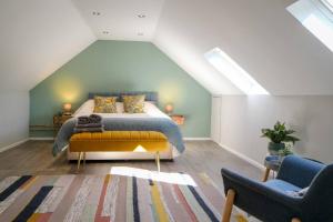 a bedroom with a bed and two chairs at Converted Stable with Hot Tub in Ilkley