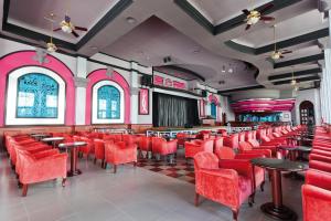 a restaurant with red chairs and tables and a stage at Riu Palace Mexico - All Inclusive in Playa del Carmen