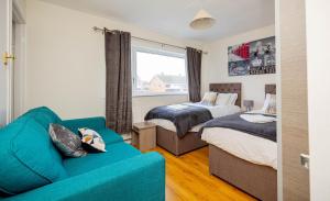 a living room with two beds and a couch at Saviour Manor in Kettering