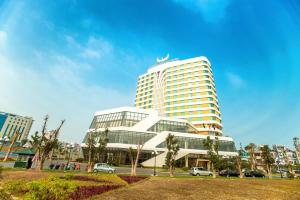 un edificio alto con macchine parcheggiate di fronte di Muong Thanh Grand Bac Giang Hotel a Bắc Giang