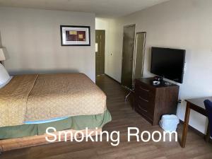 a hotel room with a bed and a flat screen tv at Days Inn by Wyndham Perryville in Perryville