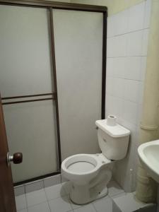 a bathroom with a toilet and a sink at Residencias MARGARITA in Manizales