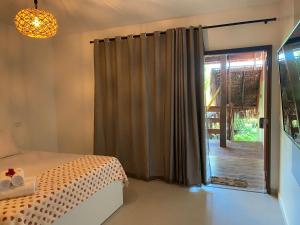 a bedroom with a bed and a sliding glass door at Pousada Águas de Tamandaré in Tamandaré
