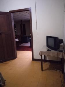 a room with a tv on a table and a door at Residencias MARGARITA in Manizales
