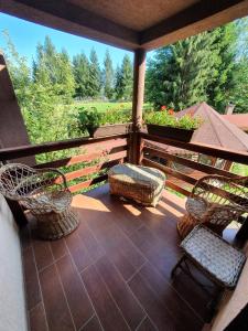 a balcony with chairs and a view of a garden at Pensiunea Valea Galbenei in Arieşeni