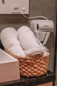 a basket of towels on a counter with a hair dryer at Pousada Refúgio do Vale - Praia do Rosa in Praia do Rosa