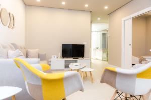 uma sala de estar com cadeiras amarelas e uma televisão em Apartamento DENVER - Centro, Nuevo, Diseño, Wifi em Valladolid