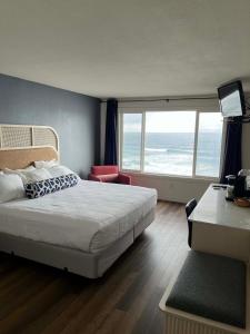 a bedroom with a bed and a view of the ocean at Seagull Beachfront Inn in Lincoln City