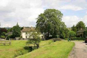 un campo de hierba con una casa en el fondo en The Little House, en Cotherstone