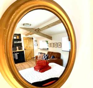 un miroir reflétant le salon avec un canapé dans l'établissement The Little House, à Cotherstone