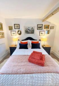 a bedroom with a large bed with two red pillows at The Little House in Cotherstone