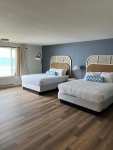 1 dormitorio con 2 camas y pared azul en Seagull Beachfront Inn en Lincoln City