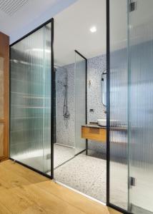 a glass pivot door in a bathroom with a sink at Galata Rasso Hotel in Istanbul