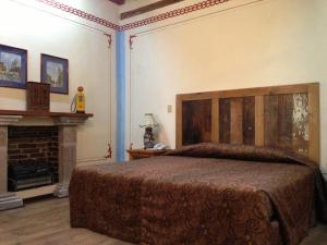a bedroom with a large bed and a fireplace at Hotel Travel in Puebla
