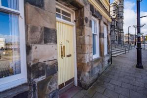 a yellow door on the side of a building at Double Ensuite Bedroom near Edinburgh in Kirkcaldy