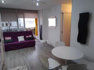 a living room with a purple couch and a table at Sitges Oasis in Sitges