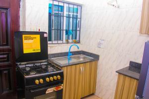 cocina con fogones, fregadero y ventana en Unique 1BEDROOM Shortlet Stadium Rd with 24hrs light-FREE WIFI -N35,000 en Port Harcourt