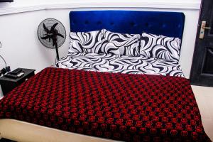 - un lit avec une couverture rouge et noire dans l'établissement Unique 1BEDROOM Shortlet Stadium Rd with 24hrs light-FREE WIFI -N35,000, à Port Harcourt