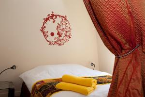 a bedroom with a bed with yellow towels on it at 52 Clichy Bed & Breakfast - Chambre d'hôtes in Paris