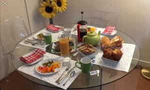 einem Glastisch mit Teller mit Lebensmitteln darauf in der Unterkunft 52 Clichy Bed & Breakfast - Chambre d'hôtes in Paris